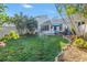 Large grassy backyard with mature landscaping, patio area, and partial fence at 992 San Carlos Ne Ct, St Petersburg, FL 33702