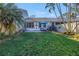Expansive grassy backyard with mature trees, patio furniture, and partial fencing at 992 San Carlos Ne Ct, St Petersburg, FL 33702