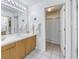 Bright bathroom featuring a white vanity, large mirror, and a separate shower with a white curtain at 992 San Carlos Ne Ct, St Petersburg, FL 33702