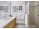 Updated bathroom with neutral walls, wood cabinets, framed art, and tiled shower with glass door at 992 San Carlos Ne Ct, St Petersburg, FL 33702