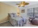 Comfortable bedroom with a ceiling fan, a reading chair, and a decorative headboard at 992 San Carlos Ne Ct, St Petersburg, FL 33702