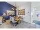 Dining room with a rustic wooden table, chandelier, and decorative artwork on a blue accent wall at 992 San Carlos Ne Ct, St Petersburg, FL 33702