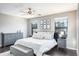 Spacious bedroom with a ceiling fan, two windows, gray furniture and dark wood floors at 10249 Villa Palazzo Ct, Tampa, FL 33615