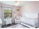 Bright Bedroom with a white crib, chair, and window at 10249 Villa Palazzo Ct, Tampa, FL 33615