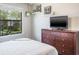 Bedroom with view, dresser with a television, and tasteful artwork at 10249 Villa Palazzo Ct, Tampa, FL 33615