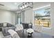 Bright dining area featuring a modern light fixture, gray walls and view of the backyard through a large window at 10249 Villa Palazzo Ct, Tampa, FL 33615