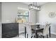 Dining room showcasing a modern light fixture, wood-look floors, and a view through a bright window at 10249 Villa Palazzo Ct, Tampa, FL 33615