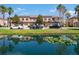 Townhomes with garages are reflected in a pond with palm trees in this attractive community at 10249 Villa Palazzo Ct, Tampa, FL 33615