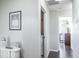 Hallway with white walls and dark wood flooring leads to the laundry room and other living spaces at 10249 Villa Palazzo Ct, Tampa, FL 33615