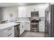 Modern kitchen with stainless steel appliances, white cabinets, marble backsplash and countertops at 10249 Villa Palazzo Ct, Tampa, FL 33615