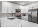 Bright kitchen featuring white cabinets, stainless steel appliances, and marble backsplash and countertops at 10249 Villa Palazzo Ct, Tampa, FL 33615