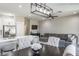Open-concept living room with a modern light fixture, gray sofa, and a dining table at 10249 Villa Palazzo Ct, Tampa, FL 33615