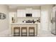Modern kitchen featuring white cabinetry, stainless steel appliances, a breakfast bar, and plenty of counter space at 106 Lilyan Ct, Rotonda West, FL 33947