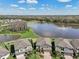 Aerial view of lakeside homes with manicured lawns, paver driveways, and serene water views in a planned community at 10845 Sundrift Dr, Tampa, FL 33647