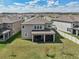 Aerial view of the home's backyard featuring a covered patio, green lawn, and a white fence for privacy at 10845 Sundrift Dr, Tampa, FL 33647
