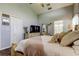 Light and airy main bedroom with ceiling fan, a large mirror, and an entrance to the main bathroom at 11207 Cypress Reserve Dr, Tampa, FL 33626