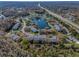 Aerial view of a community with a central pond, fountain, and tree-lined streets at 1182 Pine Ridge W Cir # B1, Tarpon Springs, FL 34688
