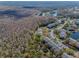 Aerial view of a neighborhood surrounded by lush green trees and a pond at 1182 Pine Ridge W Cir # B1, Tarpon Springs, FL 34688