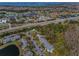 An aerial view of a community featuring condos, a lake, and a distant view of a body of water at 1182 Pine Ridge W Cir # B1, Tarpon Springs, FL 34688