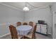 Well-lit dining area featuring a charming table, wooden chairs, and a vintage-style cabinet at 1182 Pine Ridge W Cir # B1, Tarpon Springs, FL 34688