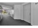 Hallway leading to a unit entrance with a fire extinguisher visible on the left at 1182 Pine Ridge W Cir # B1, Tarpon Springs, FL 34688