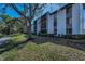 Exterior view of condos with screened balconies and mature trees at 1182 Pine Ridge W Cir # B1, Tarpon Springs, FL 34688