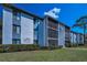 Charming condo building featuring screened balconies and a lush green lawn at 1182 Pine Ridge W Cir # B1, Tarpon Springs, FL 34688
