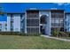 Condo building boasting screened balconies, a well-manicured lawn, and convenient pathway access at 1182 Pine Ridge W Cir # B1, Tarpon Springs, FL 34688