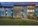 Inviting condo building featuring screened balconies and lush landscaping creates a welcoming curb appeal at 1182 Pine Ridge W Cir # B1, Tarpon Springs, FL 34688