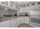 Open kitchen with white cabinets, stainless steel appliances, and an adjacent dining area at 1182 Pine Ridge W Cir # B1, Tarpon Springs, FL 34688