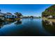 Scenic view of a tranquil pond with a fountain, surrounded by residential buildings at 1182 Pine Ridge W Cir # B1, Tarpon Springs, FL 34688