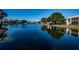 Scenic view of a tranquil pond with a fountain, surrounded by residential buildings at 1182 Pine Ridge W Cir # B1, Tarpon Springs, FL 34688