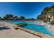 Community pool and hot tub with lounge chairs surrounded by mature landscaping under clear blue skies at 1182 Pine Ridge W Cir # B1, Tarpon Springs, FL 34688