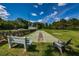 Recreational shuffleboard court featuring a shaded bench and lush green surroundings at 1182 Pine Ridge W Cir # B1, Tarpon Springs, FL 34688
