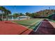 View of community tennis court and pool with surrounding landscape and community building at 1182 Pine Ridge W Cir # B1, Tarpon Springs, FL 34688