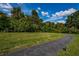 Scenic walking path winds through a green lawn with lush trees and a serene atmosphere at 1182 Pine Ridge W Cir # B1, Tarpon Springs, FL 34688