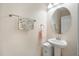 Neat powder room with a pedestal sink, stylish mirror, and a floral-patterned towel at 11965 Cinnamon Fern Dr, Riverview, FL 33579