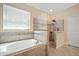 Luxurious bathroom featuring a separate shower, soaking tub, and tiled walls at 11965 Cinnamon Fern Dr, Riverview, FL 33579