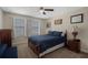 Cozy bedroom with a ceiling fan, carpeted floor, and three windows bringing in lots of natural light at 11965 Cinnamon Fern Dr, Riverview, FL 33579