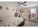 Bright bedroom featuring a ceiling fan, floral bedding, and a charming vanity area at 11965 Cinnamon Fern Dr, Riverview, FL 33579