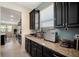 Granite kitchen counter featuring black cabinetry, stainless steel appliances, and a window at 11965 Cinnamon Fern Dr, Riverview, FL 33579