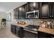 Kitchen showcasing granite countertops, stainless steel appliances, and dark cabinetry at 11965 Cinnamon Fern Dr, Riverview, FL 33579