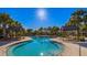 A luxurious pool with sun loungers is surrounded by palm trees in this tropical community at 11965 Cinnamon Fern Dr, Riverview, FL 33579