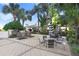 Outdoor grill area with stainless steel barbecue, dining tables, chairs, umbrellas and lush greenery at 1209 E Cumberland Ave # 1703, Tampa, FL 33602