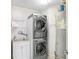 Modern laundry room with stacked washer/dryer, utility sink and cabinet, with an efficient water heater at 1209 E Cumberland Ave # 1703, Tampa, FL 33602