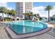 Beautiful pool with palm trees and lounge chairs in a resort-style setting next to an upscale condominium building at 1209 E Cumberland Ave # 1703, Tampa, FL 33602