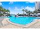 Expansive outdoor pool area with palm trees, lounge chairs, poolside cabanas, a bridge, and a charming waterfall feature at 1209 E Cumberland Ave # 1703, Tampa, FL 33602