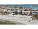 Scenic aerial view of beachfront property and pristine sandy beach with sun umbrellas at 12924 Gulf Blvd # 110, St Petersburg, FL 33708