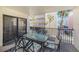 Outdoor balcony featuring a glass table, seating, and partial views of tropical landscaping at 12924 Gulf Blvd # 110, St Petersburg, FL 33708