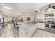 Bright kitchen open to the living area, features white cabinetry, marble countertops, and stainless steel appliances at 12924 Gulf Blvd # 110, St Petersburg, FL 33708